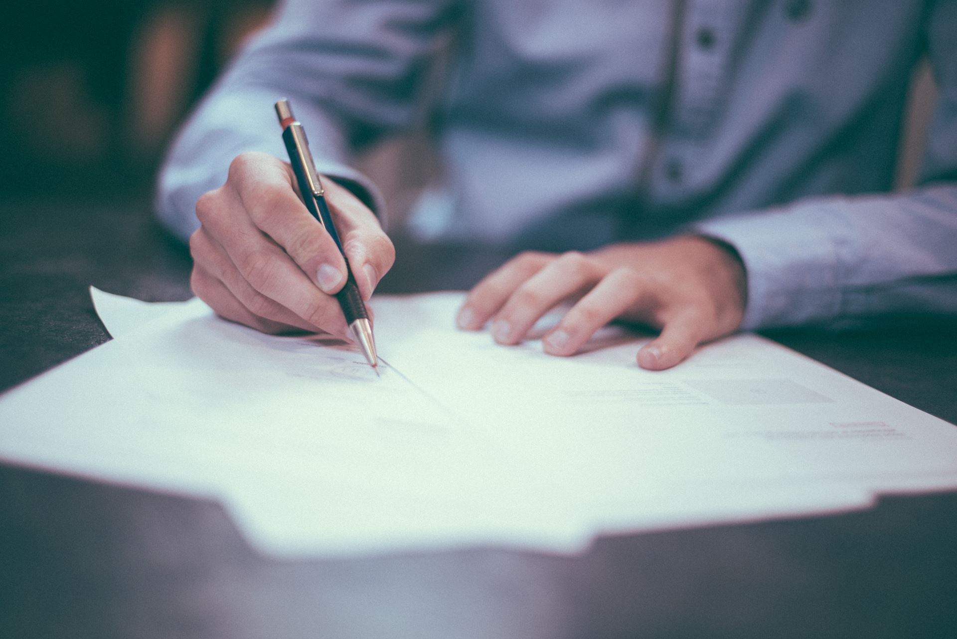 a person sitting on a table completing paperwork